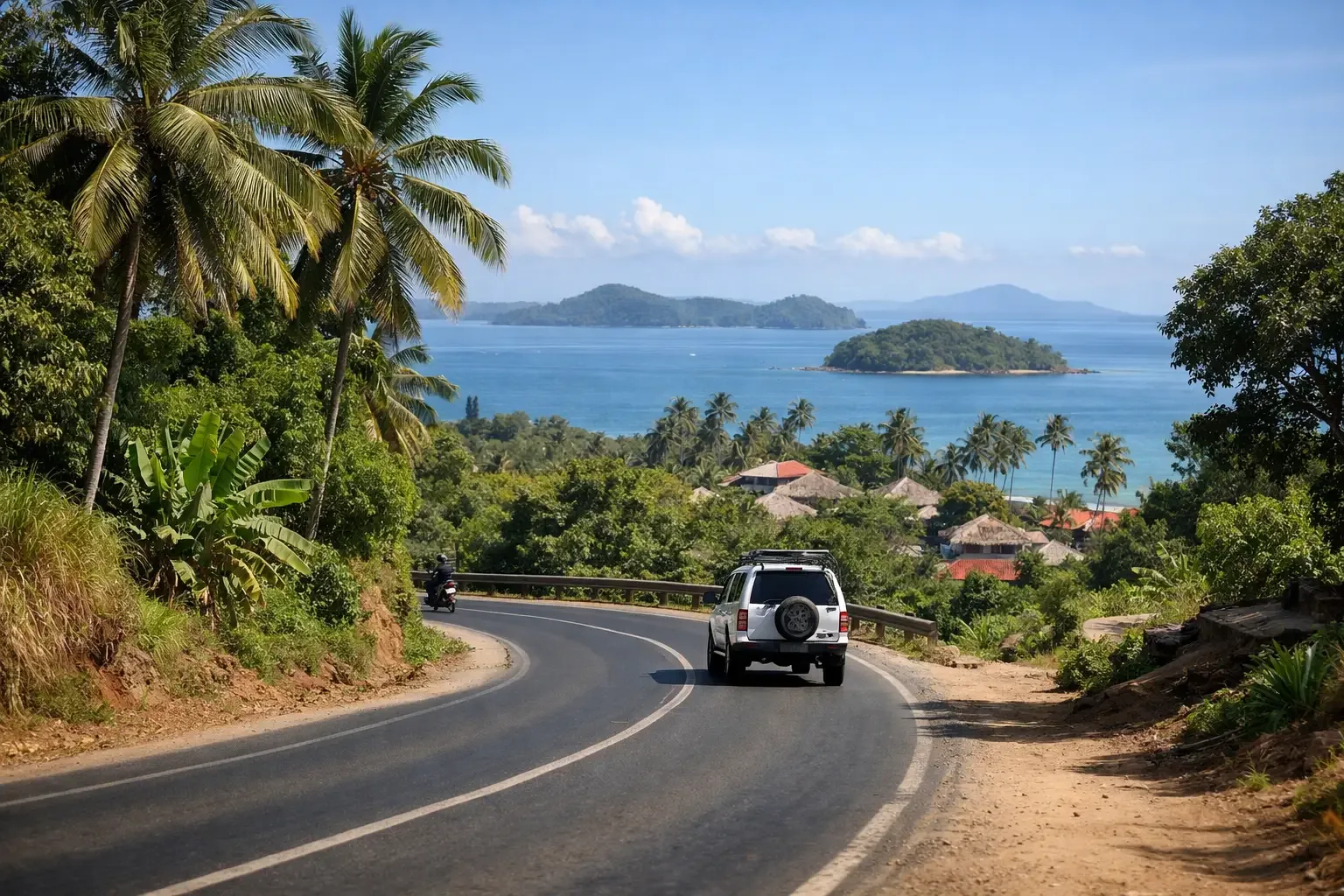 Route côtière praticable à Nosy Be, bordée de palmiers, avec un véhicule en circulation